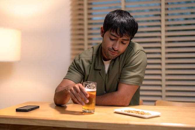 一人でビールを飲む、暗い表情の男性