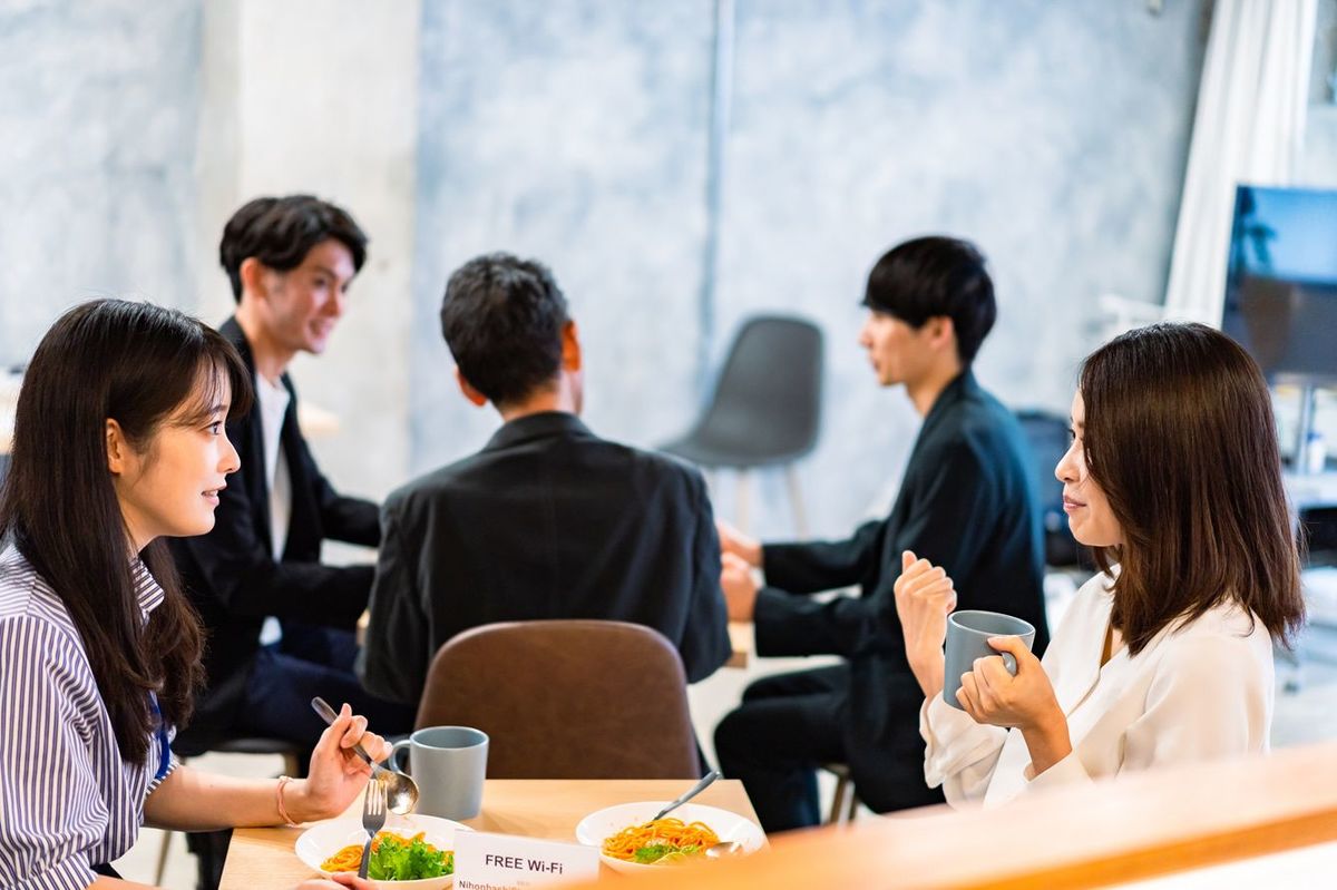 会社の食堂で昼食をとっているサラリーマン