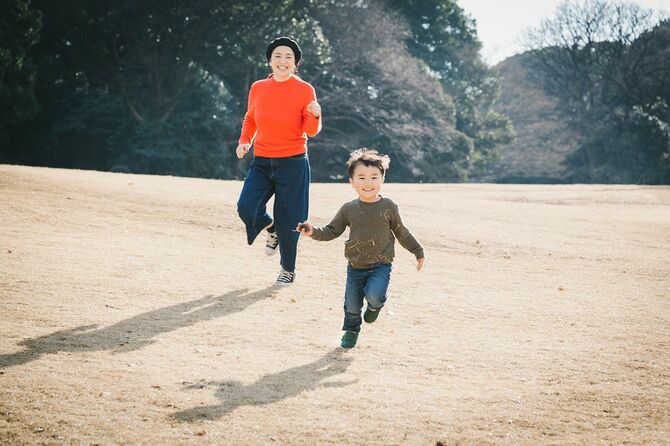 公園で遊んでいるアジアの母と息子。