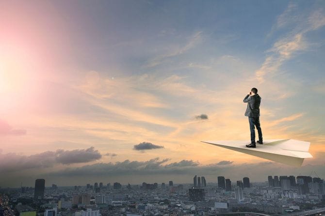 都市の上を飛ぶビジネスマン