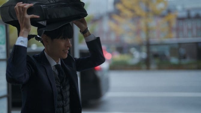 雨の中を急いで走る人