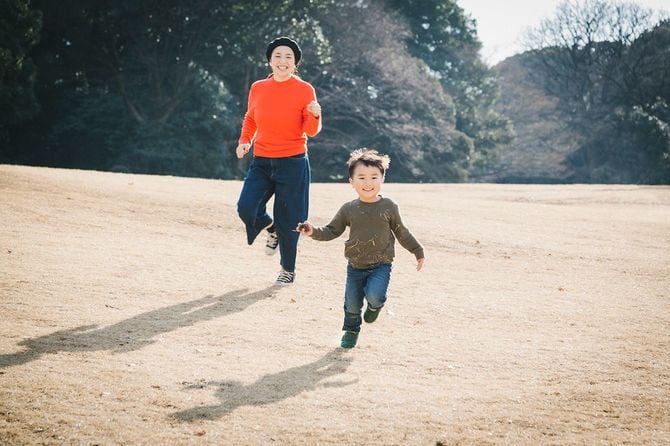 公園で遊んでいるアジアの母と息子。