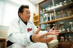 初のプロ出身監督となった慶應義塾大学野球部の江藤省三監督（68歳）。応接室には歴代の優勝杯が並ぶ。