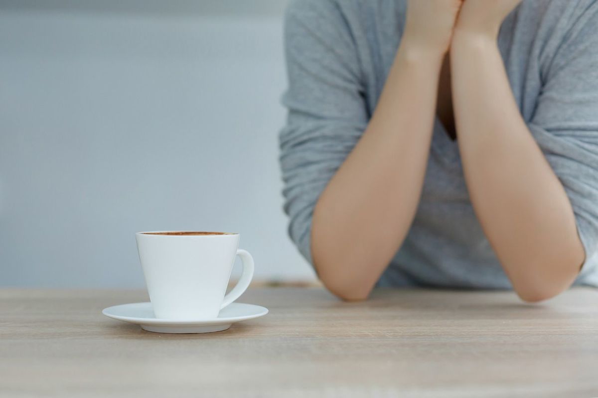 女性の前に置かれたコーヒー