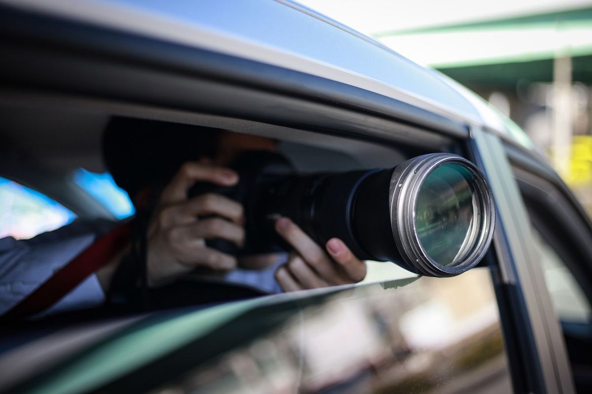 車の中から写真を撮っている男