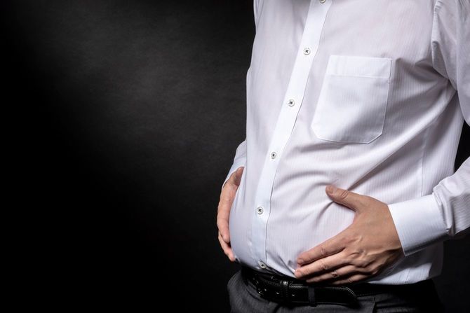 太った腹を気にする男性