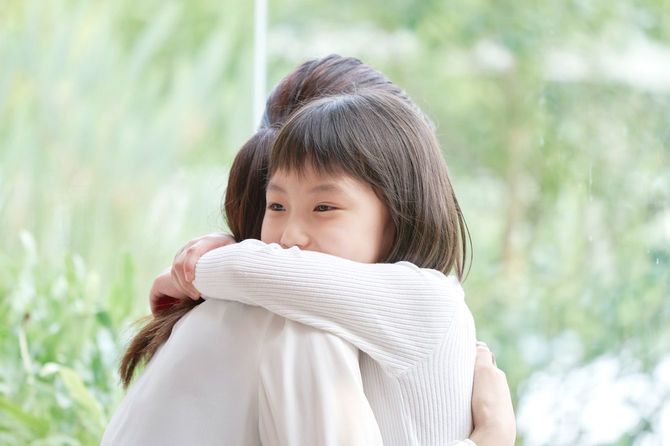 娘を抱きしめる母親