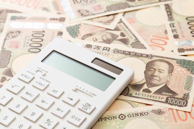 敷き詰められた一万円札の上に電卓