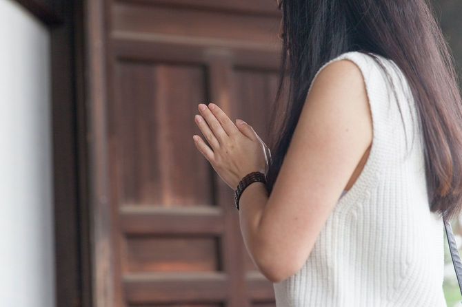 寺で拝んでいる女性