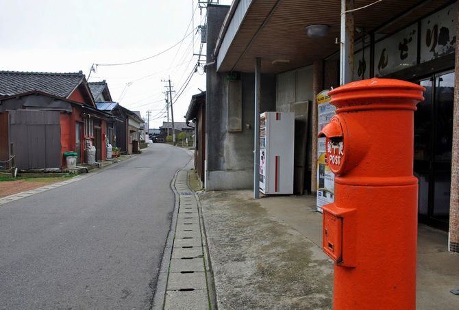 人けのない集落に、赤いポストがある風景