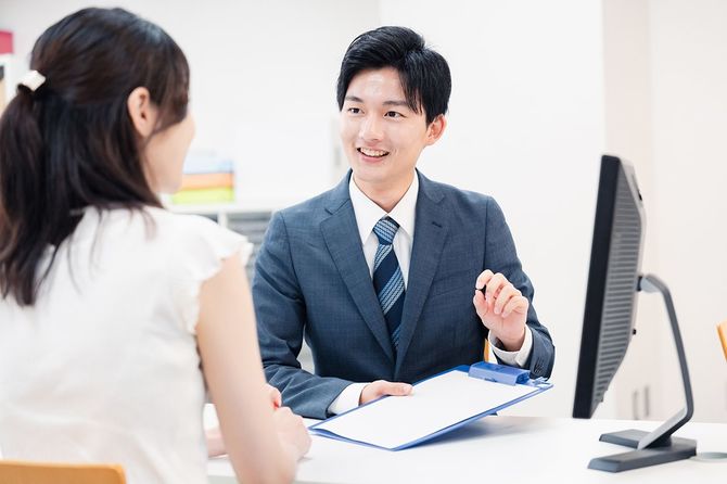 カウンターで客の要望に耳を傾ける男性スタッフ