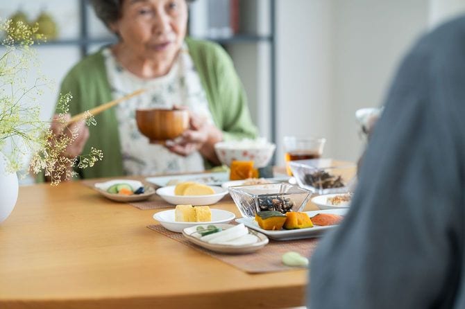 息子と食事をする高齢女性のイメージ