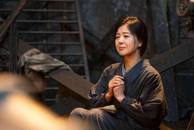 空襲で焼け落ちた自宅の跡で、焼け残った賛美歌集を膝の上に置いて「うるわしの白百合」を歌う光子（薬師丸ひろ子）。連続テレビ小説「エール」月～土8：00（NHK総合）