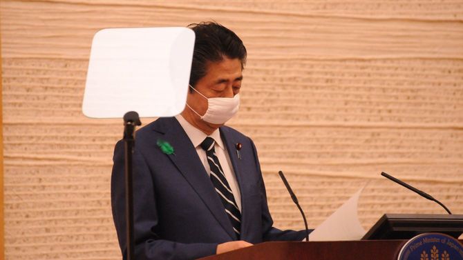 原稿を確認する安倍首相。手前には透明なパネルに文字を映し出す「プロンプター」がある。