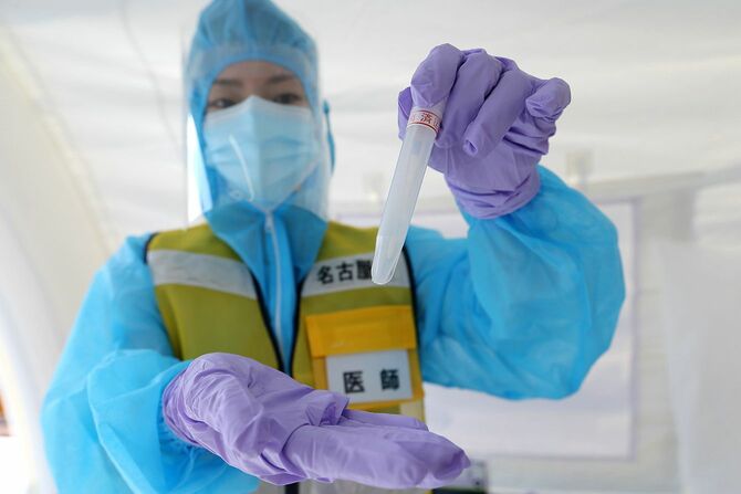 軽症者の検査を集中的に行う「名古屋市PCR検査所」の開設を前に、報道陣に公開されたドライブスルー方式検査のデモンストレーション。写真はスワブ（綿棒）で鼻腔（びくう）から採取した検体を入れる容器＝2020年5月20日、同市内