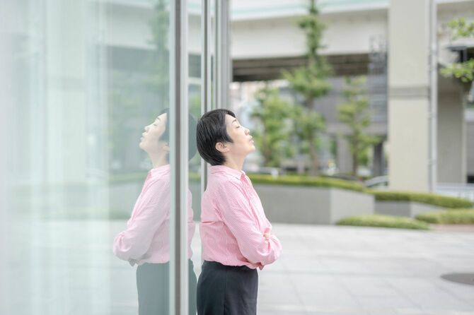 外に出て呼吸を整える日本のビジネスウーマン