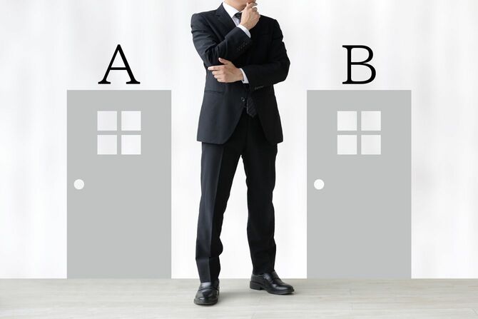 AとBのドアの間で悩むビジネスマン