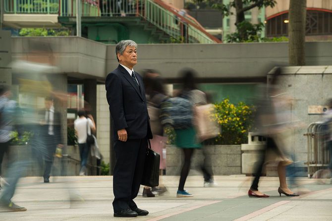 街にたたずむスーツ姿の高齢者