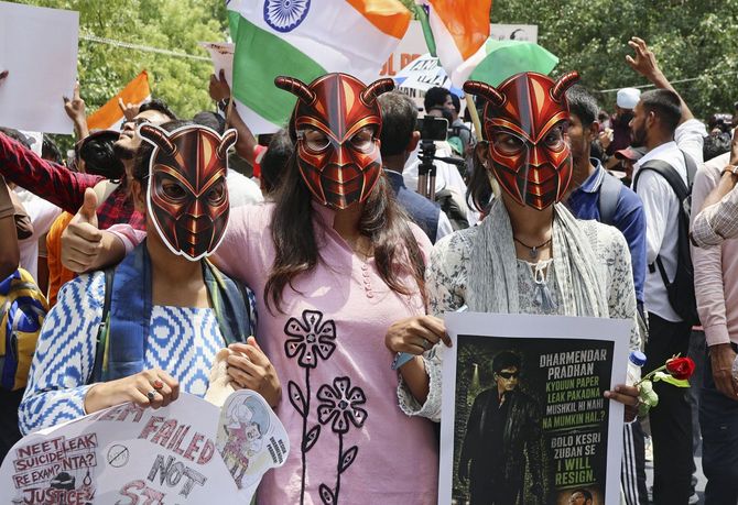 ゴキブリを模したお面をかぶった抗議集会の参加者=2026年6月20日、インド・ニューデリー(共同)
