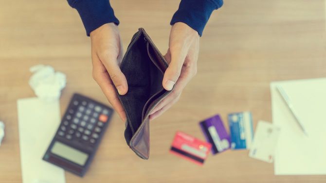 空の財布を開く男の手