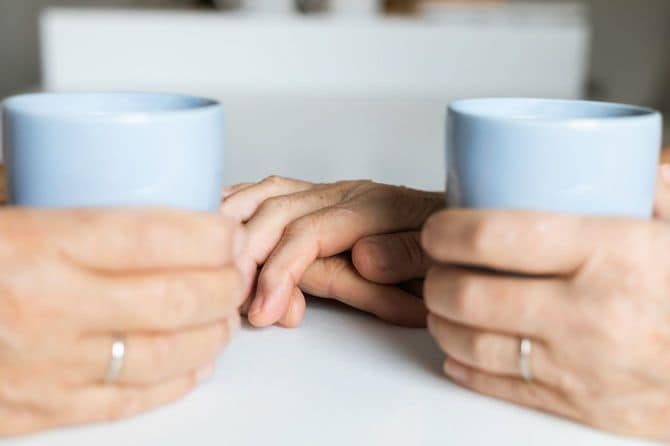 シニア夫婦は互いに手を握り合っている