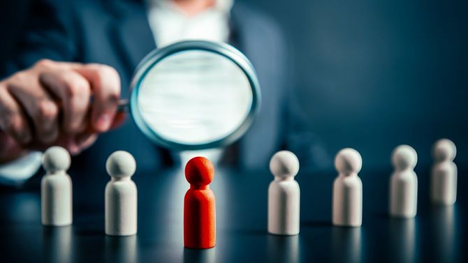 虫眼鏡で見る赤い木製人形