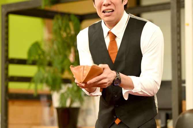 空の財布を取り出して焦る男性