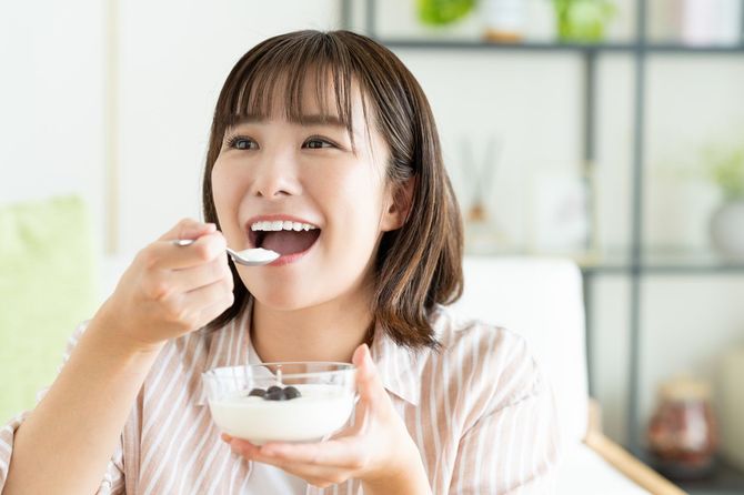 ヨーグルトを食べる若い女性