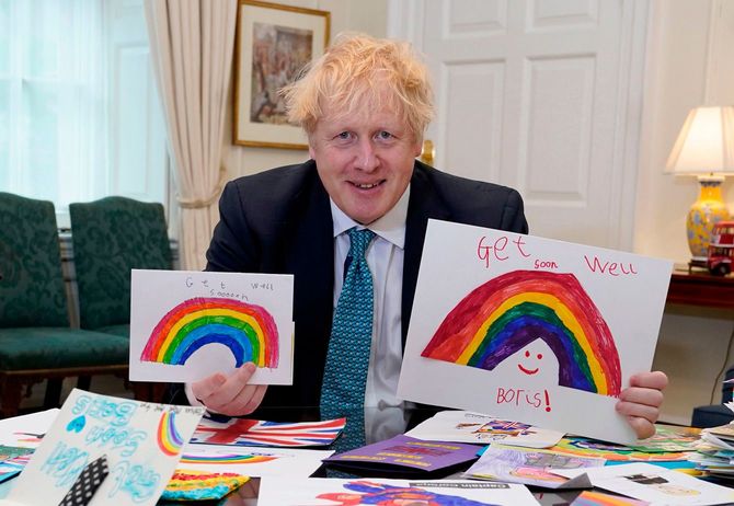 子どもたちから送られたお見舞いカードを見せるボリス・ジョンソン首相。2020年4月28日撮影（イギリス・ロンドン）