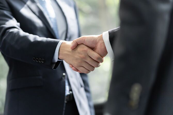 日本人男性ビジネスマンが握手を交わす