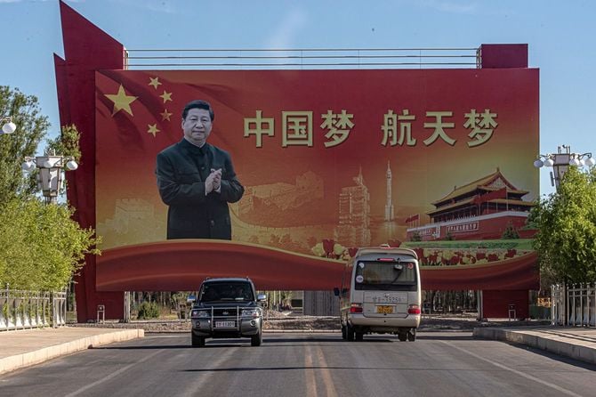 2021年6月16日、中国北西部の甘粛省にある酒泉衛星発射センターで、「神舟12号」を搭載した「長征2F」ロケットの打ち上げ前日、車両が習近平中国国家主席の肖像が描かれた横断幕の前を通り過ぎている