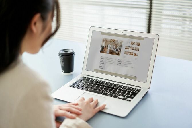 ノートパソコンで不動産サイトを見る女性