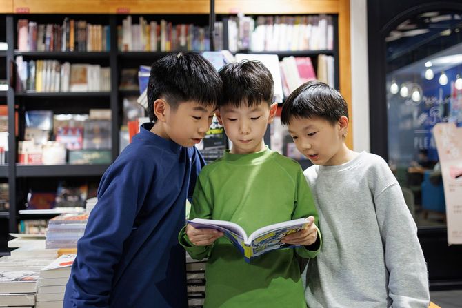 3人の男の子が書店で立ち読み