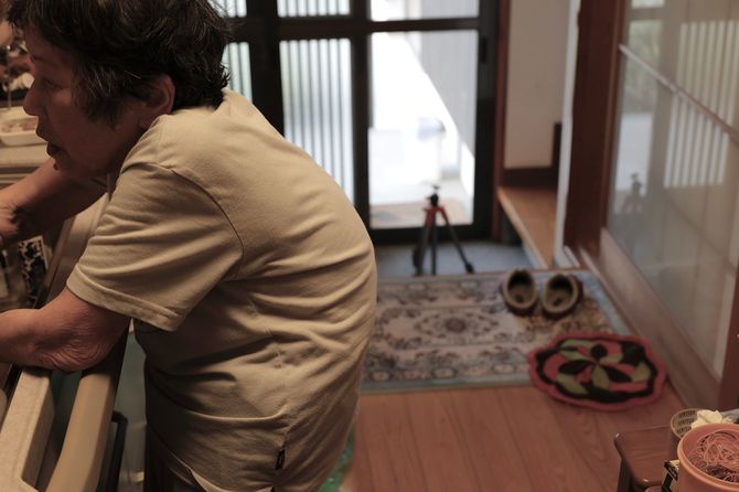 台所に立つ、腰の曲がったシニア女性