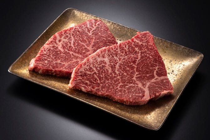 金色の皿にのったステーキ用の肉