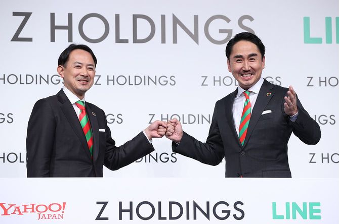 記者会見で撮影に応じる、Zホールディングス(HD)共同最高経営責任者(CEO)の川辺健太郎氏(左、ZHD社長)と出沢剛氏(LINE社長)=2021年3月1日、東京都港区