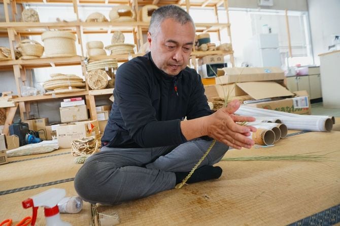 わらを編む酒井さん