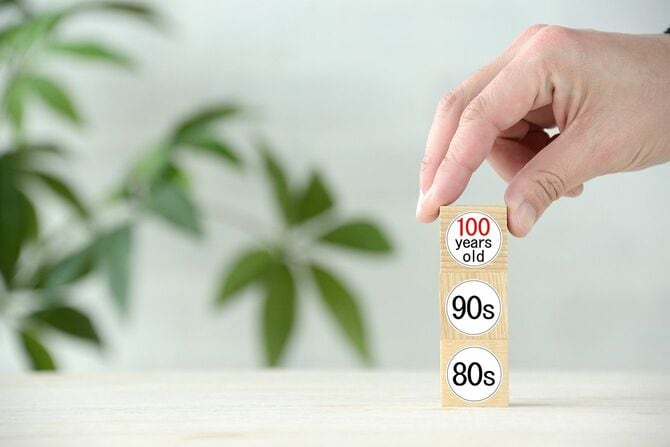 「100歳」という言葉で木のブロックを掘り起こす人間の手