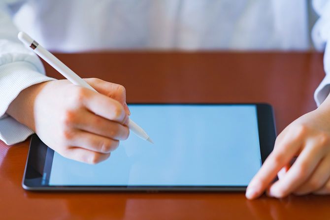 リビングルームでペンタブレットを使って勉強する子供