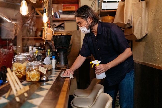 飲食店のカウンターを消毒する人