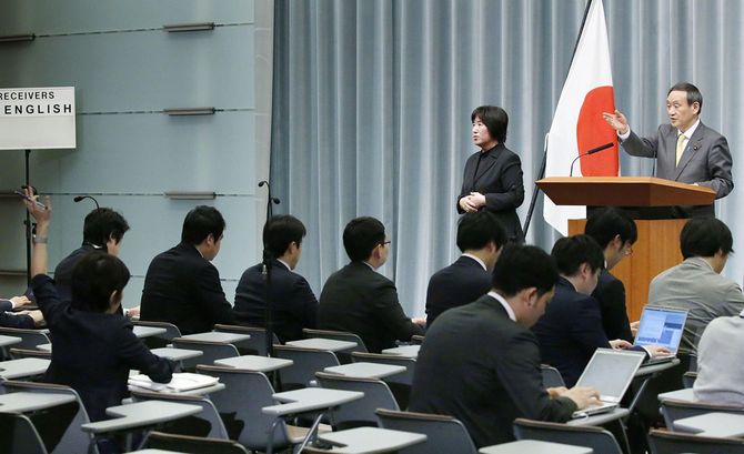 質問のため挙手する東京新聞の望月衣塑子記者（左端）。右端は菅官房長官＝2019年3月13日、首相官邸
