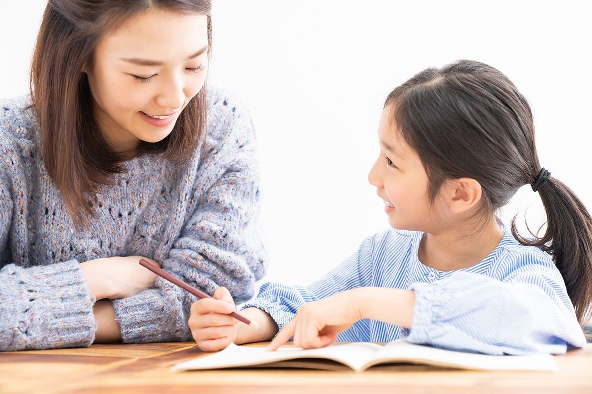 子どもの勉強を見る母親