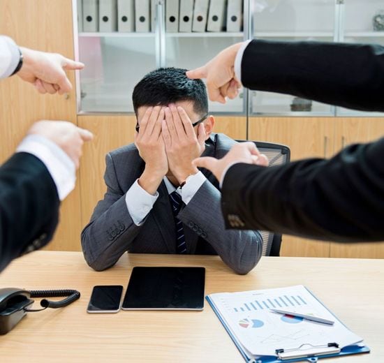 4人に集中的に指弾され、顔を手で覆っている男性