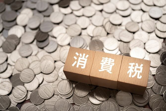 敷き詰めたコインの上の「消費税」と書かれたブロック