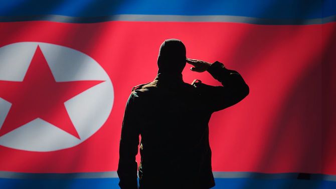 北朝鮮の国旗に向かって敬礼する手のジェスチャーをする秘密諜報員