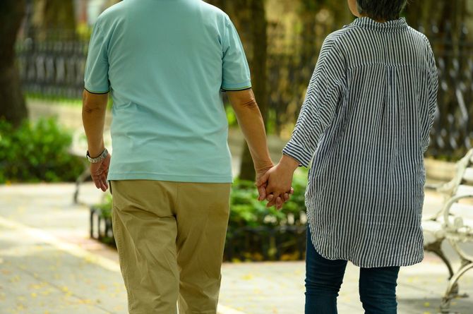 公園を歩くシニア夫婦