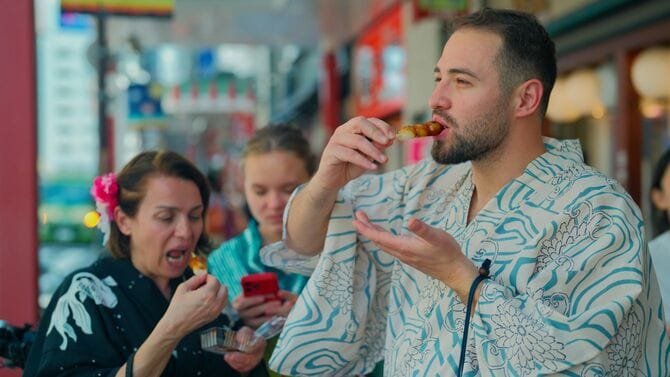 浴衣を着用してみたらし団子を堪能する訪日観光客の親子