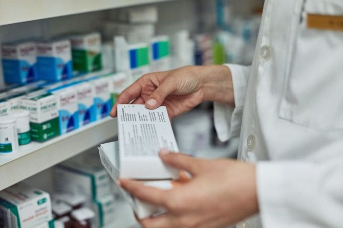 薬箱のラベルを読む薬剤師