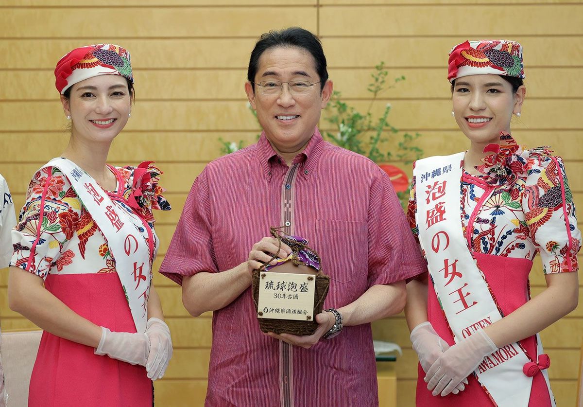 沖縄県酒造組合から琉球泡盛を贈られ、「泡盛の女王」と写真に納まる岸田文雄首相。（2023年7月24日撮影）