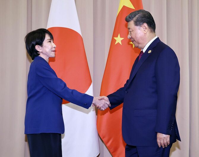 習近平国家主席(右)と握手を交わす高市首相